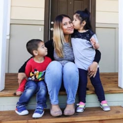 Habitat homeowner Bianca sitting on porch with her children