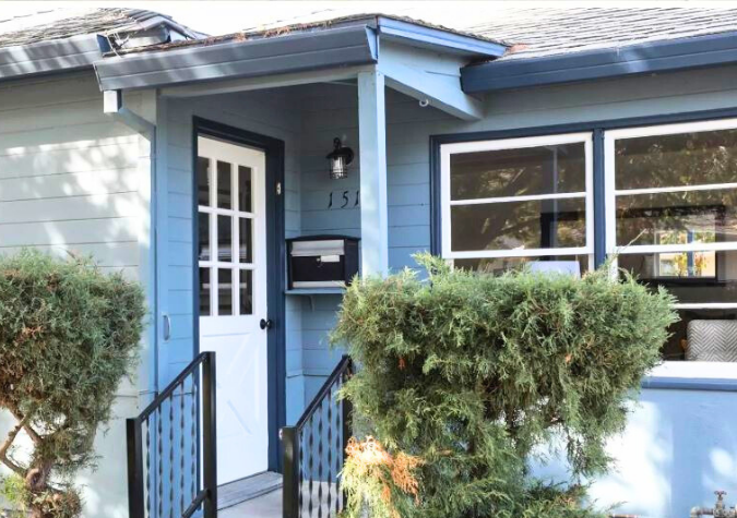 white front door of a blue bungalow home