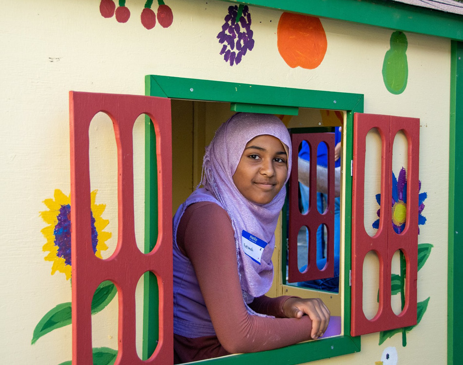 Girl looking out playhouse window